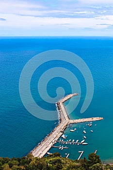 Pier in the Tyrrhenian sea by coastal Sicilian city Cefalu taken from above on a cloudy day