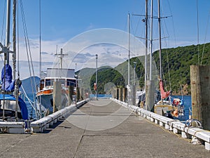 Pier on waterfront lined on either side by moored boats