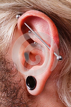 Pierced man ear, black plug tunnel, industrial and rook