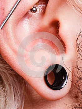 Pierced man ear, black plug tunnel, industrial and rook