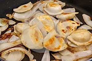Pierogi and onions in a fry pan