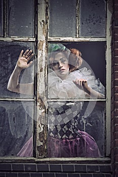 A pierrot woman behind the glass photo