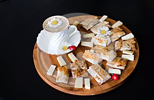 Pies made of thin pita bread with homemade cheese and herbs, a white porcelain Cup with a saucer and coffee, daisies with