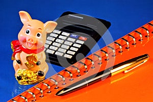 Pig calculating animal in a cheerful mood, able to anticipate events, a symbol of well-being. Notepad for important notes, a pen,