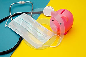 Pig moneybox, face mask and stethoscope on colorful background. Spending money on pills and expensiveness of medicine