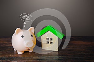 Pig piggy bank dreams of making money by selling a house. Savings and economy on utilities bills, energy efficiency of the
