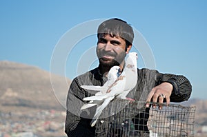 Pigeon Collector Holding A Cage With Two Birds On It