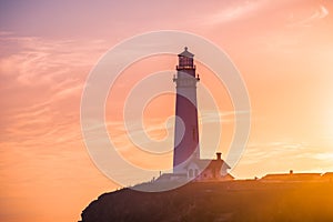 Pigeon Point Lighthouse historical building bathed in sunset light; Pacific Ocean coastline, Pescadero, California