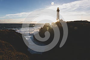 Pigeon Point Lighthouse on Northern California Pacific Ocean coastline just before sunset with an artistic sun flare, vintage look