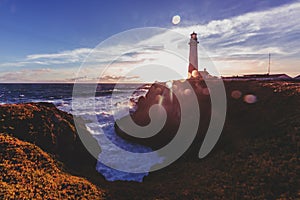 Pigeon Point Lighthouse on Northern California Pacific Ocean coastline just before sunset with an artistic sun flare, vintage look