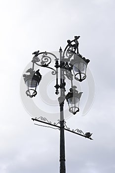 Pigeons resting on wrought iron streetlight in Sanlucar de Barrameda, Cadiz photo