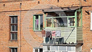 Pigeons scurrying around on the balcony of an old brick apartment building