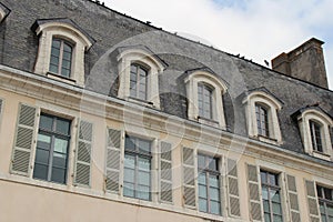 Pigeons are standing on the ridgepole of a building in Quimperle (France) photo