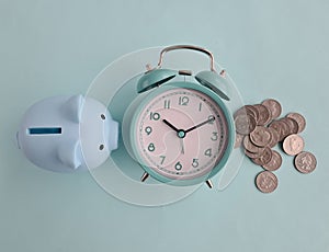 Piggy bank, alarm clock and coins. Time value of money and financial planning