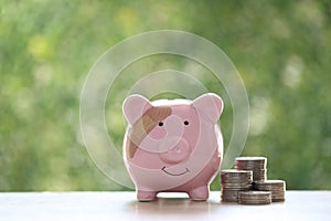 Piggy bank attached to the plaster on the head on green background, Save money for Medical insurance and Health care concept