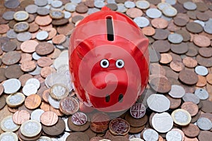 Piggy bank on background of uk coins, savings or budget concept