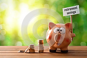 Piggy bank with billboard retirement savings on table nature background