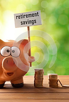 Piggy bank with billboard retirement savings on table nature vertical