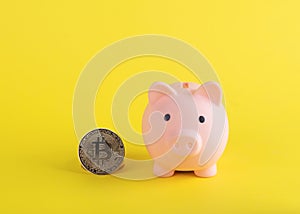 piggy bank with bitcoins and on a yellow background