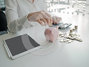 Piggy bank and business women depositing coins for saving. coins