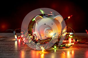 Piggy bank with Christmas string lights on happy December festival, Enjoy savings for spending money on the holiday`s concept