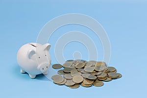 Piggy bank and coins on the blue background. Saving investment budget wealth business retirement, financial, money, banking