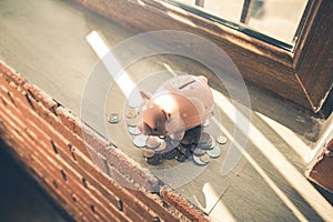 piggy bank with coins on the window.