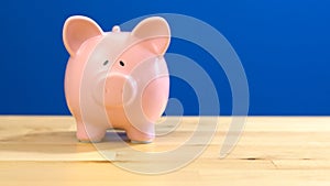 Piggy bank against blue background with copy space.