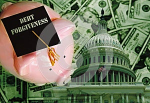 Piggy bank with Debt Forgiveness graduation cap on cash with United States capitol dome