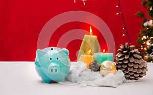 Piggy bank decorated in Christmas celebration theme on white table reb background with copy-space, family spent time together in