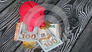 Piggy bank among dollar and euro banknotes. Cryptocurrency coins are visible. Multicurrency savings. Risk while saving money. On