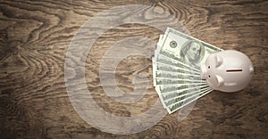 Piggy bank and dollars on wooden background