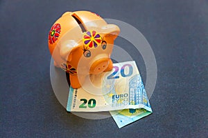 Piggy bank and euro on black background
