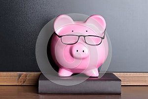 Piggy bank with eye glasses on book
