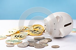 Piggy bank falling on white table with coins and blue background. savings money concept