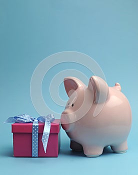 Piggy Bank with gift for savings concept - vertical with copy space.