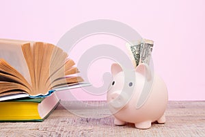 Piggy bank in glasses and books on pink background. open book. Tuition payment. Brainwork. Back to School