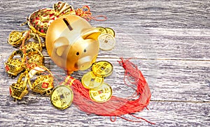 Piggy bank with golden coins and chinese ornament on the wooden table