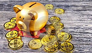 Piggy bank with golden coins and red envelopes on the wooden table