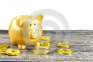 Piggy bank and golden coins on the wooden table