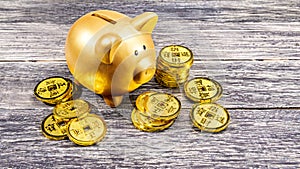 Piggy bank and golden coins on the wooden table