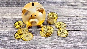 Piggy bank and golden coins on the wooden table