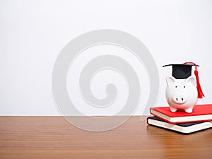 Piggy bank with graduation hat on hardcover book, Copy space for text, Back to school, Education concept