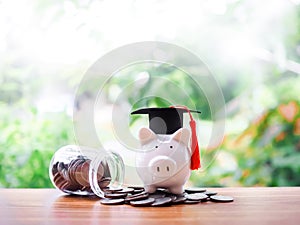 Piggy bank with graduation hat on stack of coins. The concept of saving money for education, student loan, scholarship, tuition