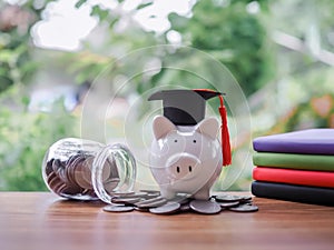 Piggy bank with graduation hat on stack of coins. The concept of saving money for education, student loan, scholarship, tuition