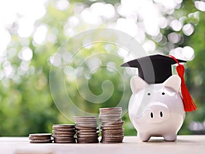 Piggy bank with graduation hat and stack of coins. The concept of saving money for education, student loan, scholarship, tuition