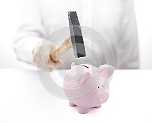 Piggy bank and hand with hammer