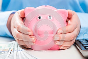 Piggy bank in the hands of its thrifty hostess