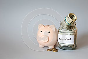 piggy bank and jar of money with inscription tax refund