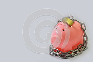 Piggy bank locked using chain and lock with some parts in focus